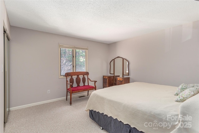 bedroom with a textured ceiling, a closet, and light carpet