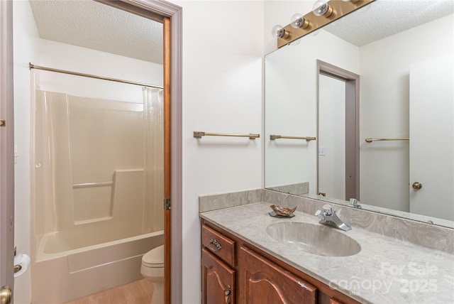 full bathroom featuring toilet, a textured ceiling, hardwood / wood-style flooring, vanity, and shower / washtub combination