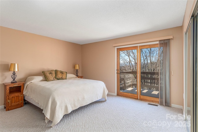 carpeted bedroom with access to exterior and a textured ceiling