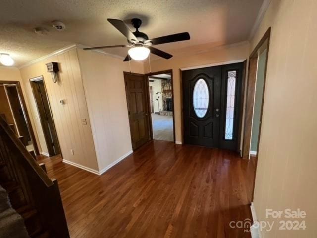 entryway with crown molding, ceiling fan, dark hardwood / wood-style floors, and a textured ceiling