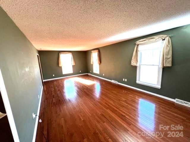 spare room with wood-type flooring and a textured ceiling