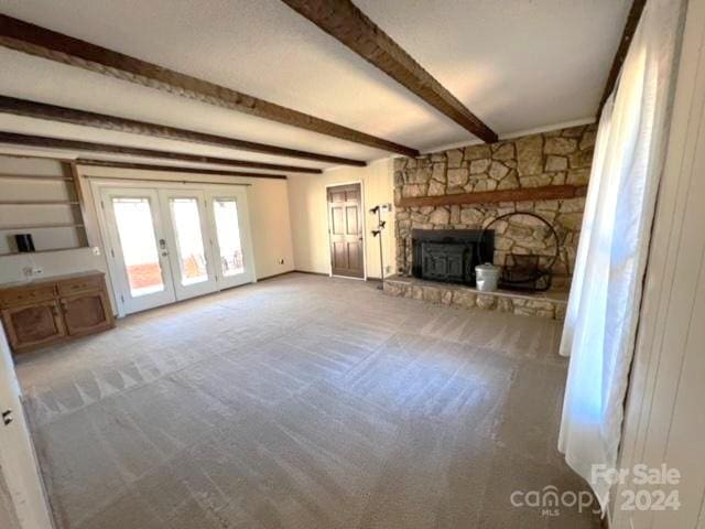 unfurnished living room with beam ceiling and french doors