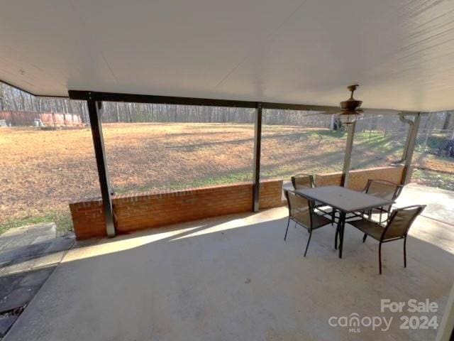 unfurnished sunroom featuring a wealth of natural light and ceiling fan