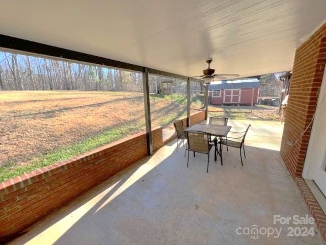 unfurnished sunroom with ceiling fan