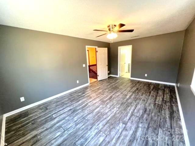 unfurnished bedroom featuring ceiling fan and dark hardwood / wood-style floors