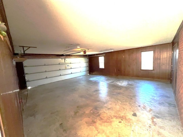 garage featuring a garage door opener and wooden walls