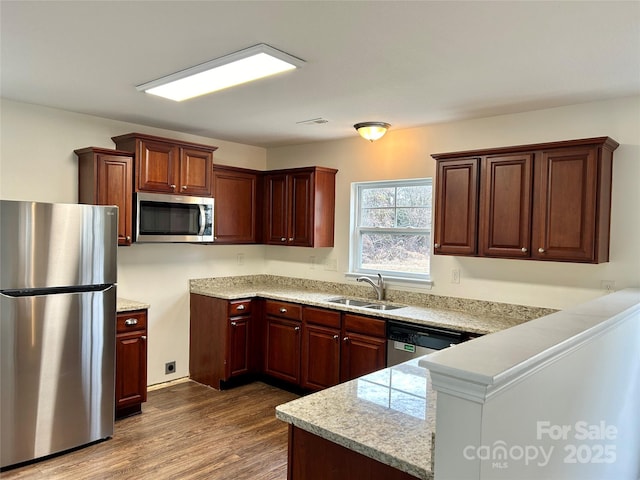 kitchen featuring stainless steel appliances, wood-type flooring, and sink