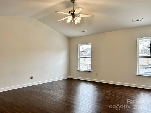 empty room featuring ceiling fan, vaulted ceiling, and dark hardwood / wood-style flooring