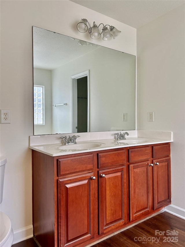 bathroom featuring hardwood / wood-style flooring, a textured ceiling, toilet, and vanity