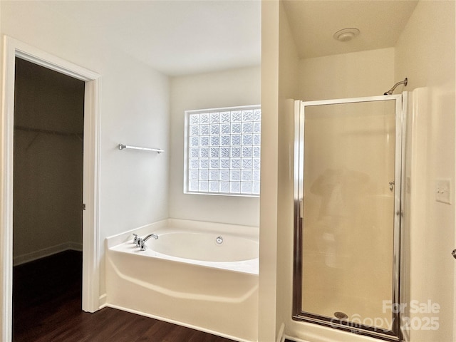 bathroom with hardwood / wood-style flooring and shower with separate bathtub