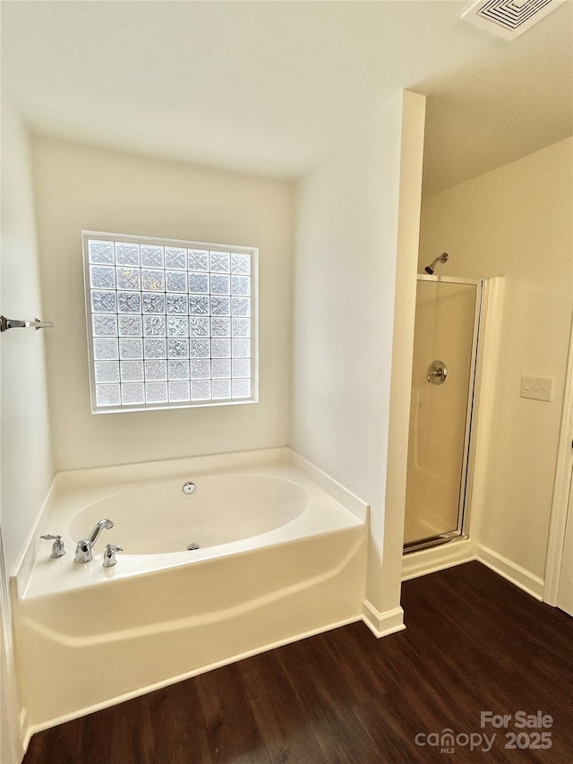 bathroom with shower with separate bathtub and hardwood / wood-style flooring