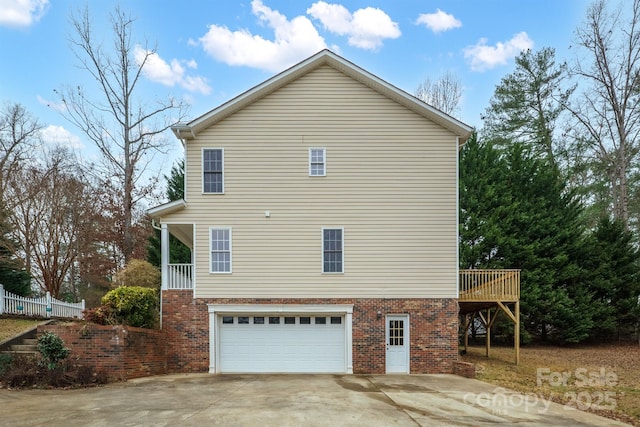 view of side of home featuring a wooden deck and a garage