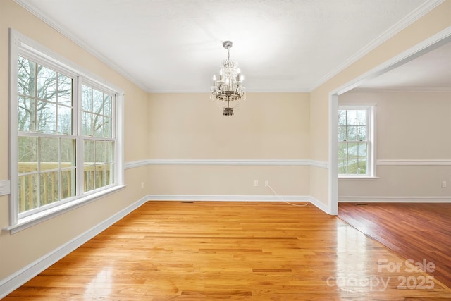 unfurnished dining area featuring an inviting chandelier, ornamental molding, and light wood-type flooring