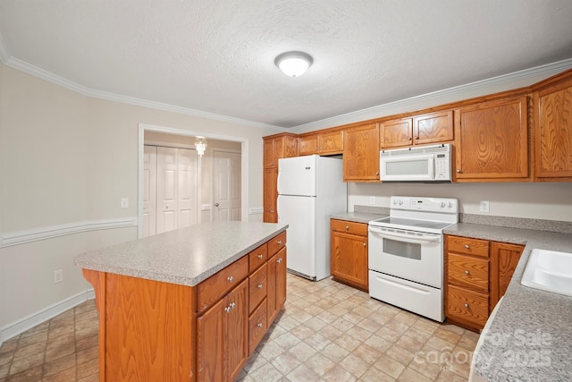 kitchen with ornamental molding, a kitchen island, a textured ceiling, and white appliances