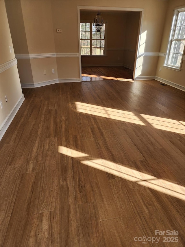 unfurnished room featuring dark hardwood / wood-style floors and a chandelier