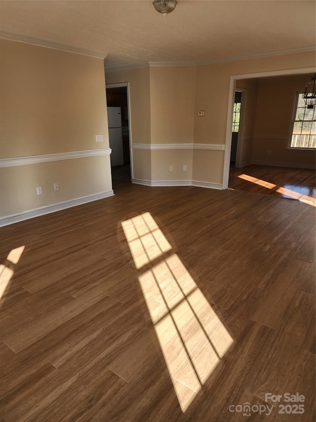 spare room featuring crown molding, a chandelier, and dark hardwood / wood-style flooring