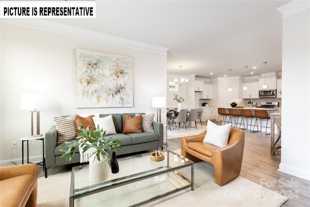 living room featuring crown molding, light hardwood / wood-style flooring, and a chandelier