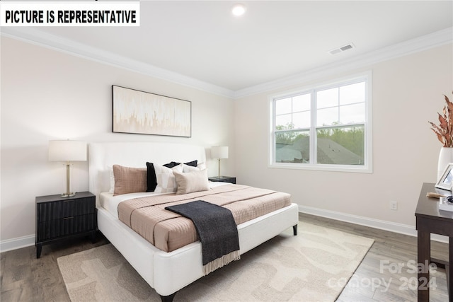 bedroom with hardwood / wood-style floors and ornamental molding