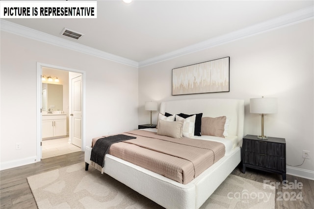 bedroom with hardwood / wood-style floors, ensuite bathroom, and crown molding