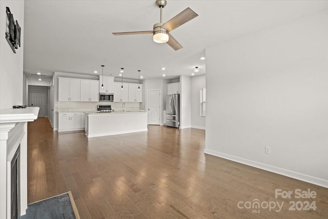 unfurnished living room featuring ceiling fan, dark hardwood / wood-style flooring, and sink