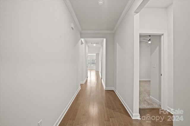 corridor featuring wood-type flooring and crown molding