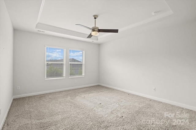 carpeted empty room featuring a tray ceiling and ceiling fan