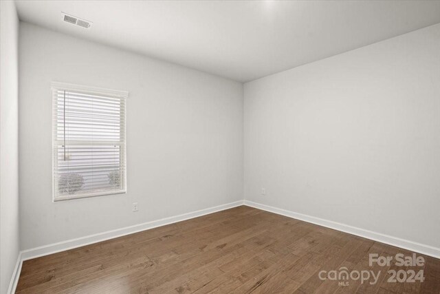 spare room featuring wood-type flooring