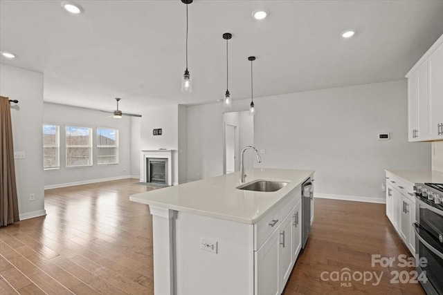 kitchen with a center island with sink, white cabinetry, stainless steel appliances, and sink