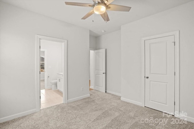 unfurnished bedroom with connected bathroom, light colored carpet, and ceiling fan