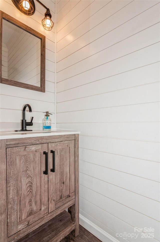 bathroom with vanity and wooden walls