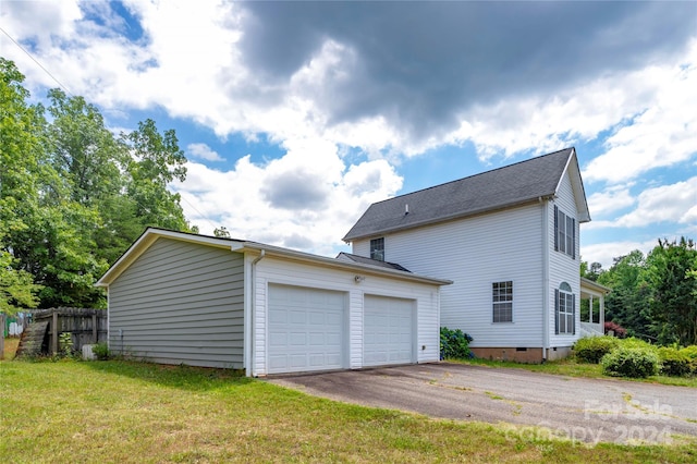 exterior space with a garage and a lawn