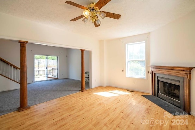 unfurnished living room with ceiling fan, a textured ceiling, and light hardwood / wood-style flooring