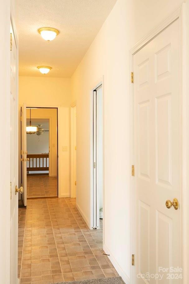 hallway with a textured ceiling