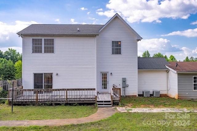 rear view of property with a lawn, central AC unit, and a deck