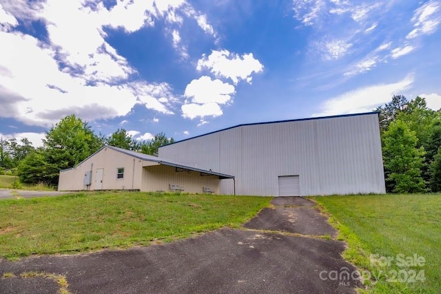 view of side of property featuring an outbuilding and a yard