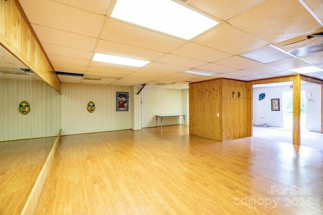 basement featuring a drop ceiling and wood-type flooring