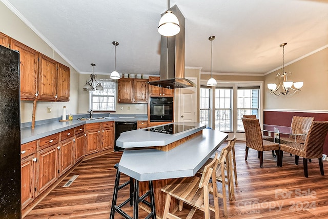 kitchen featuring dark wood-type flooring, an inviting chandelier, a kitchen bar, a kitchen island, and black appliances