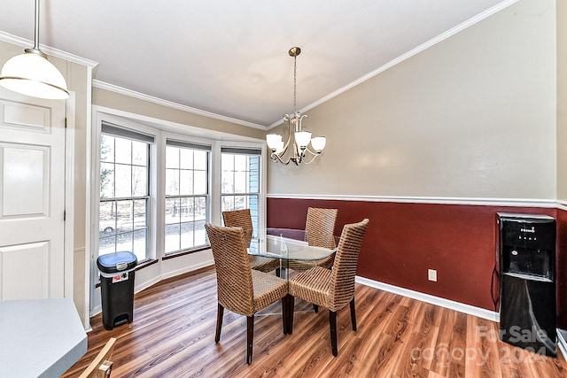 dining room featuring crown molding, dark wood-type flooring, vaulted ceiling, and a notable chandelier