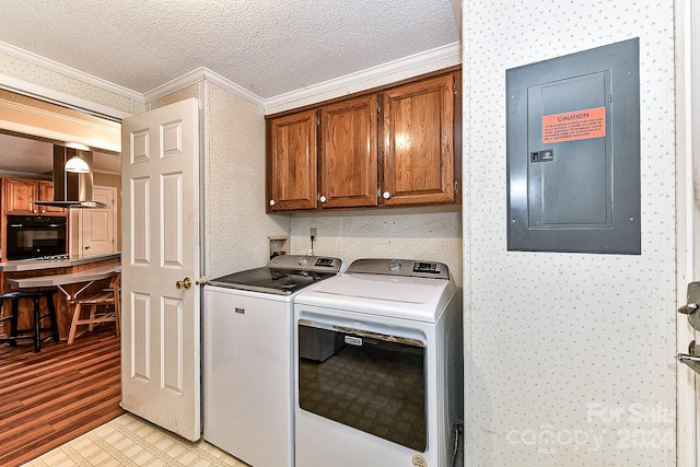 laundry room with cabinets, ornamental molding, a textured ceiling, washer and clothes dryer, and electric panel