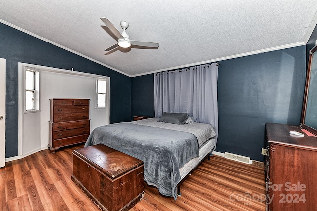 bedroom featuring a textured ceiling, hardwood / wood-style flooring, vaulted ceiling, and ceiling fan