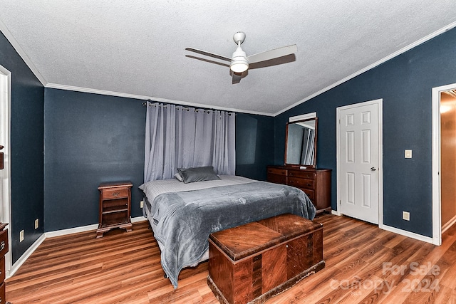 bedroom featuring ceiling fan, wood-type flooring, a textured ceiling, lofted ceiling, and ornamental molding