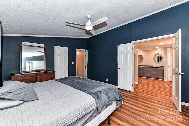 bedroom with a textured ceiling, vaulted ceiling, ceiling fan, crown molding, and hardwood / wood-style floors