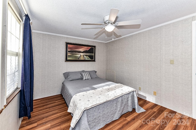 bedroom featuring ceiling fan, crown molding, dark wood-type flooring, and multiple windows