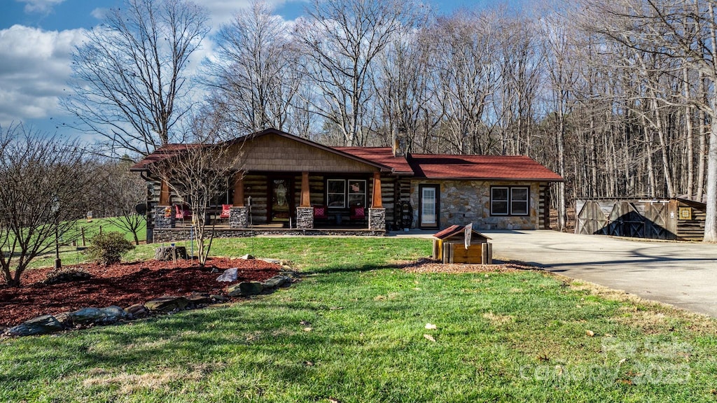 view of front of house featuring a storage unit, a porch, and a front yard