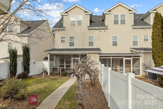 view of front of house featuring a front yard, cooling unit, and a sunroom