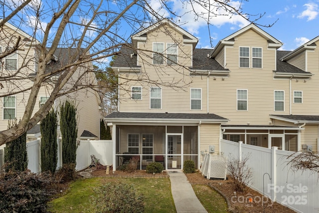 rear view of property with a yard and a sunroom