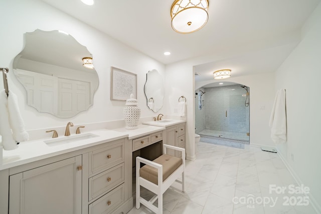 bathroom with a shower with door and vanity