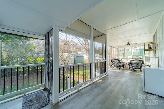 unfurnished sunroom with ceiling fan