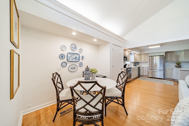 dining area featuring light hardwood / wood-style floors and lofted ceiling