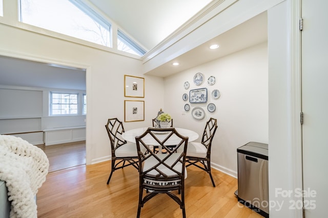 dining space featuring light hardwood / wood-style floors and lofted ceiling